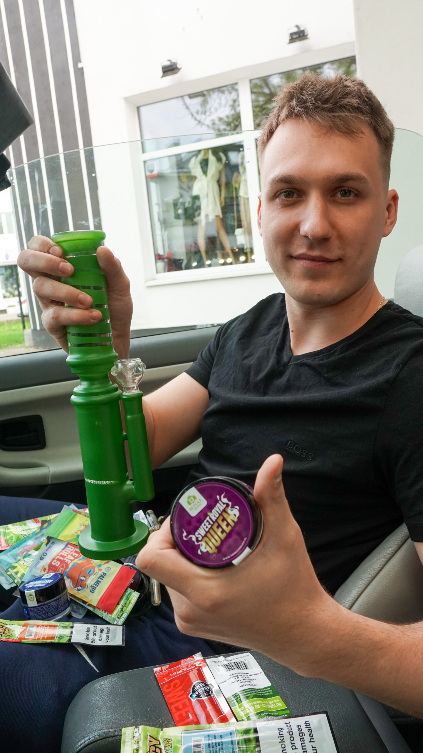 Zdjęcie sprzedawcy trzymającego bongo i susz CBD