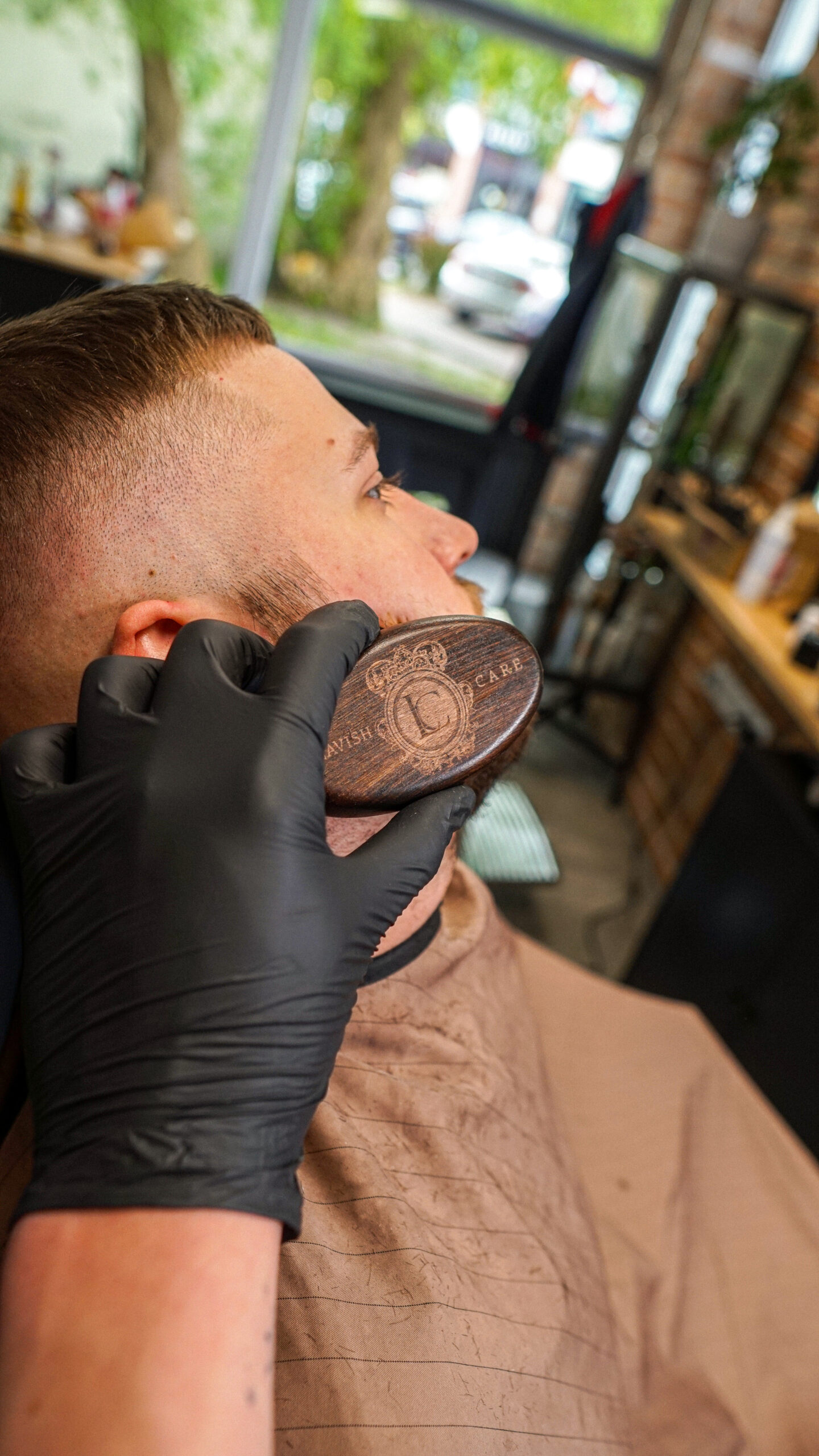 Zdjęcie z czesania brody klienta szczotką z włosia dzika